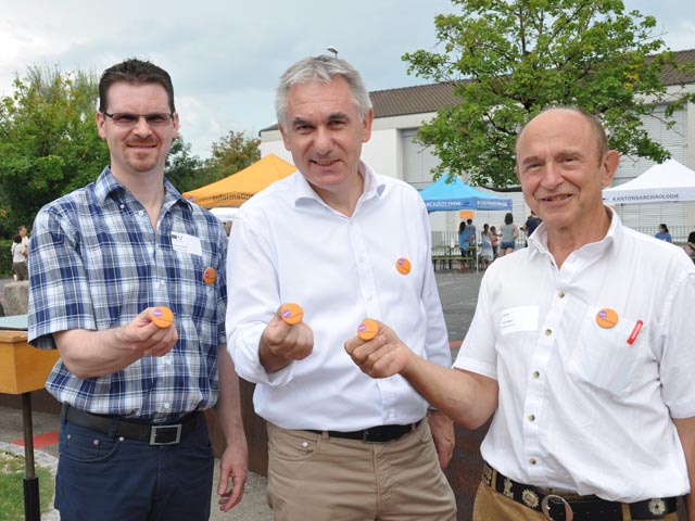 Regierungsrat Alex Hürzeler (Mitte), Gemeindeammann Arpad Major (rechts) und Kantonsarchäologe Thomas Doppler präsentieren den Button mit dem neuen Label «Hallo! Kulturerbe.» Foto: Jörg Wägli