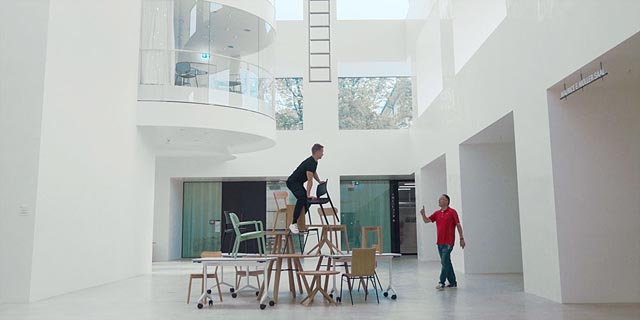 Mann klettert auf Stühle. Foto: Universität Basel