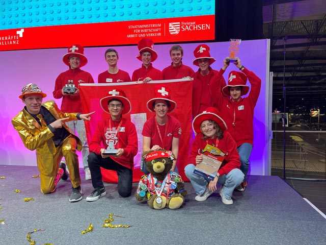 Bild: hinten v.l.: Tim Föhner, Baden; Coach: Amos Burchia, Bözberg; Yaron Traub, Stetten; Coach: Benedikt Amsler, Zeihen; Casimir Winzenried, Erlinsbach; Jorge Bertrán de Lis Orozco, Rütihof; vorne v.l.: Moderator Tim, Tobias Nemet, Lengnau; Yuri Honegger, Rütihof; Ella Robinson, Muri. Foto: Michael Föhner