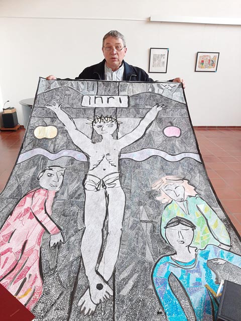 Der Künstler Sylvain Bouillard mit seinem Kruzifixgemälde aus einer Million Kringeln. Foto: zVg