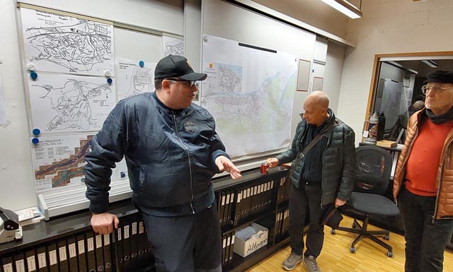 In der Einsatzzentrale der Feuerwehr: Kommandant Marc Leber erklärt interessierten Teilnehmern die Alarmierung der Feuerwehr. Foto: zVg
