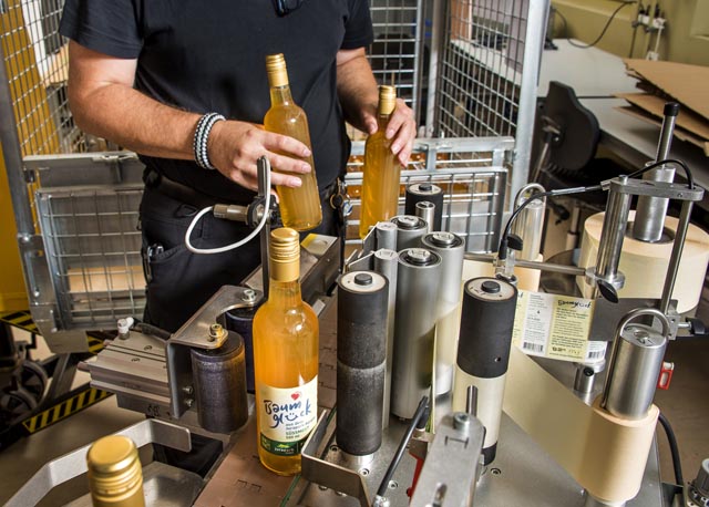 Bei der Stiftung MBF werden die Glasflaschen für Coop etikettiert. Foto: © Markus Hässig / Coopzeitung
