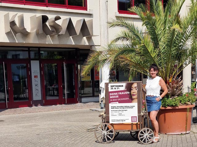 Veranstalterin Anja Inderwildi mit dem «Frauenmesse»-Plakat vor dem Kursaal Bad Säckingen, wo die Messe stattfinden wird. Foto: zVg
