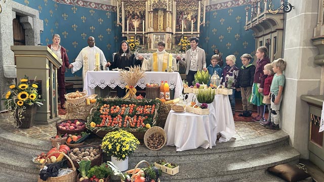 Das Liturgieteam mit den Erst- und Zweitklässlern vor den kunstvoll zubereiteten Erntegaben. Foto: Klaus Hollinger
