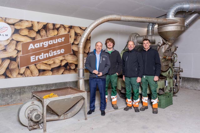 Von links: Regierungsrat und Landwirtschaftsdirektor Dr. Markus Dieth, Fabian Salm, Hansjörg Salm und Manuel Salm. Im Hintergrund die 100-jährige Kaffeeröstmaschine. Foto: Basler Aarau