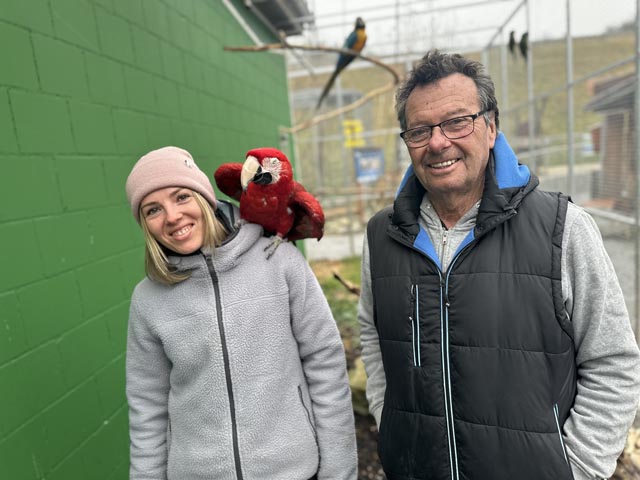Noemi Appert ist dem Vogelpark seit Jahren treu und längst die rechte Hand von Rolf Lanz geworden. Hier stehen die beiden in der Flugvoliere der Papageien mit «Pascha», der seinem Namen alle Ehre macht. Foto: Sonja Fasler