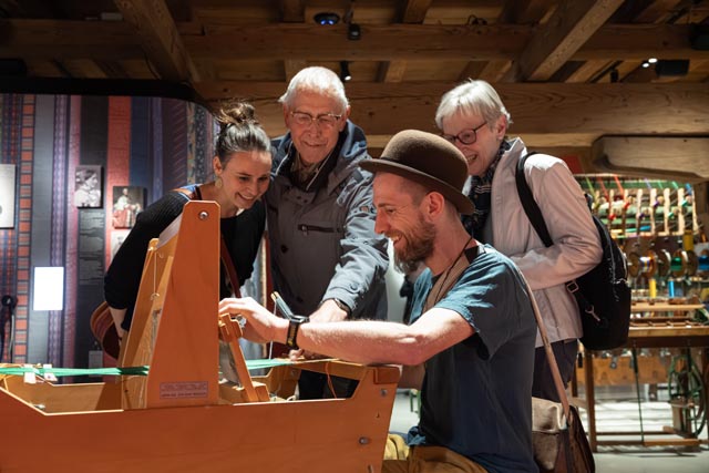 Gemeinsam weben in der Ausstellung «Seidenband». Foto: Museum.BL