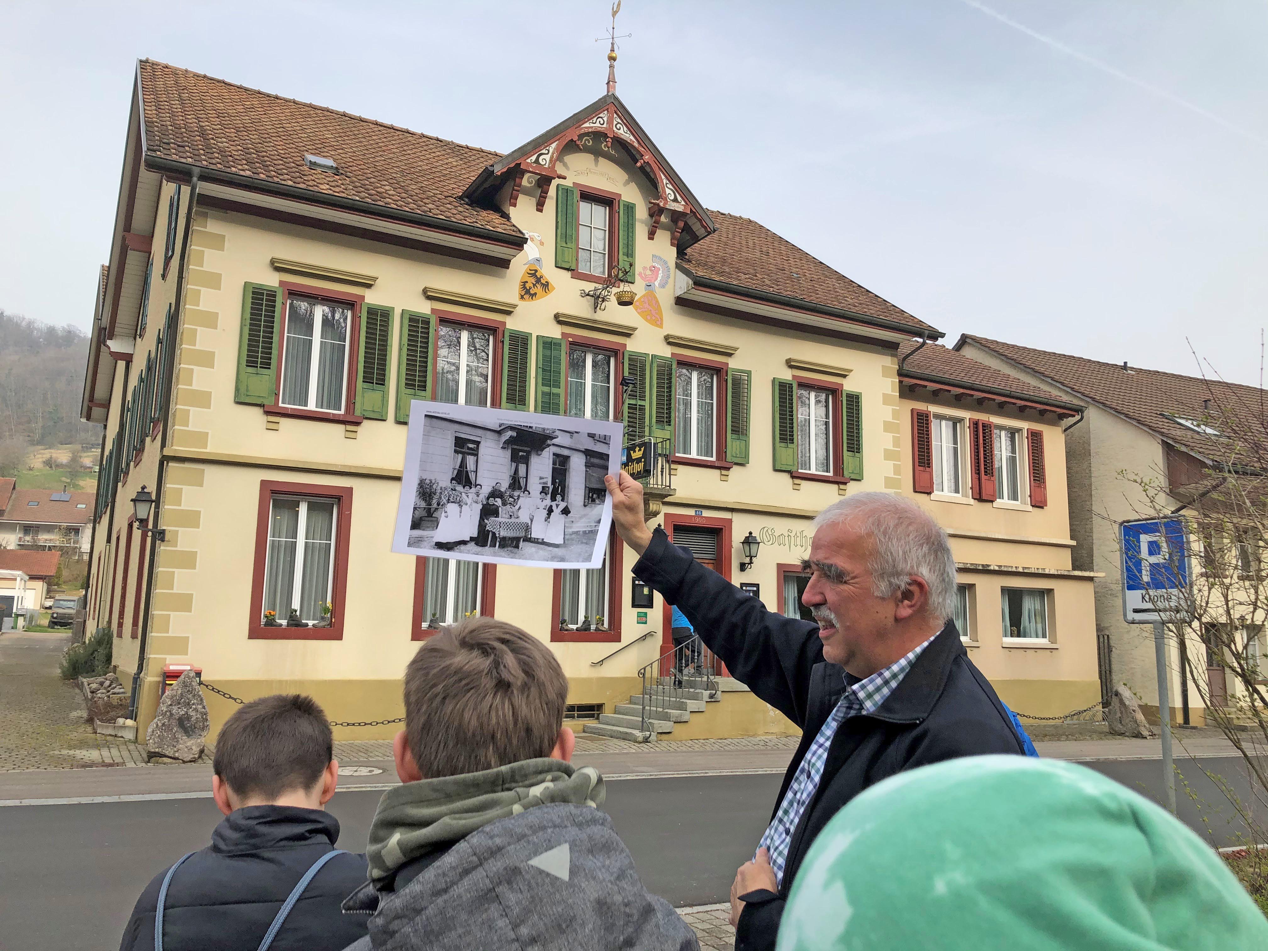 Wie Detektive folgen die Schüler und Schülerinnen den historischen Spuren im Dorf und spannen den Bogen bis in die Gegenwart; auf dem Bild Christoph Benz mit Schülern vor der «Krone» Wittnau. Foto: zVg